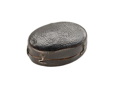 Colour photograph. A brown ovular case made from an uneven, leather-like material, divided in half, with lower and upper lids joined by silver hook fastenings, photographed against a white background.